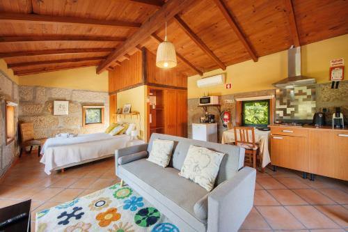 a living room with a couch and a kitchen at Casa de Andrães Loft Heras in Marco de Canaveses