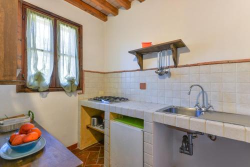 a kitchen with a sink and a bowl of fruit on a counter at Agriturismo Amandolo in Cavo