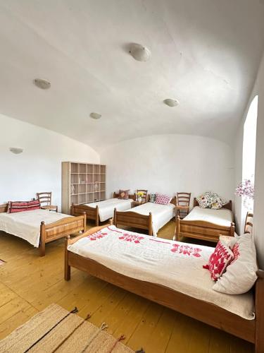 a room with four beds and a couch at Stúdió apartman in Kővágóörs