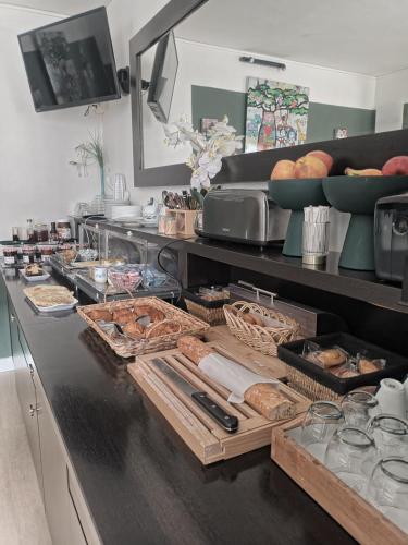 a kitchen with a counter with bread and other foods at The Originals Boutique, Hôtel d'Angleterre, Le Havre, centre, plage in Le Havre