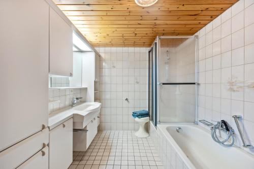 a bathroom with a tub and a sink and a toilet at Ferienwohnung Schuhmacher in Donaueschingen