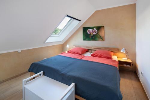 a bedroom with a bed with red pillows and a window at Leben am Weinberg in Herbstein