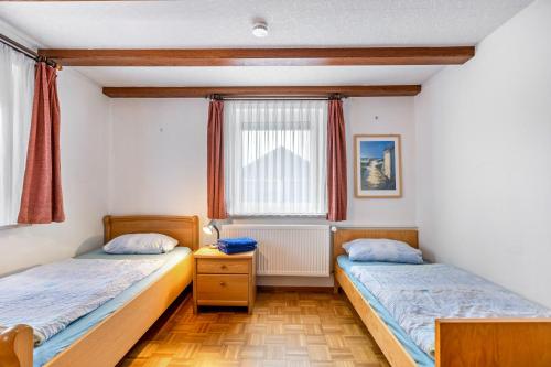 two beds in a room with a window at Ferienwohnung Schuhmacher in Donaueschingen