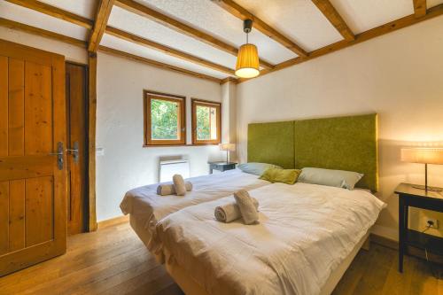 a bedroom with a large bed with two pillows on it at Gabbro-Chalet Moderne Tout Confort in Villard-Reculas