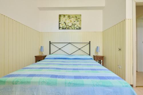 a bedroom with a large bed with a blue comforter at Mare Etrusco 4 in Populonia