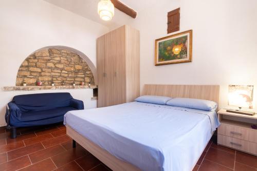 a bedroom with a bed and a blue chair at Torre Cappavecchia in Molfetta