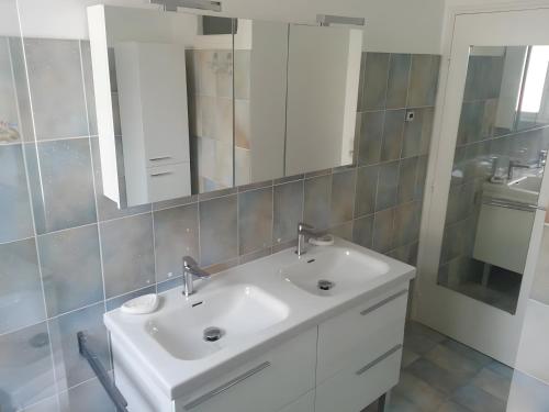 a bathroom with a white sink and a mirror at Le Nid Marin - 76 in Pornic