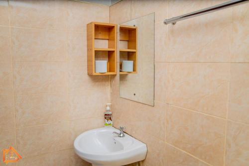 a bathroom with a sink and a mirror at Bethany Cushy Home Ltd in Kisii