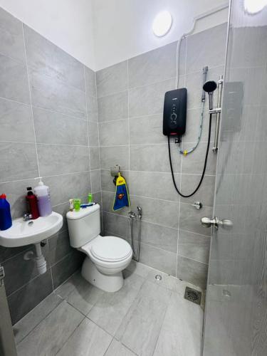 a bathroom with a shower with a toilet and a sink at Pitstop Homestay Klia in Banting