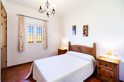 a bedroom with a white bed and a window at Luisa 3 in Conil de la Frontera