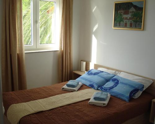 a bedroom with a bed with two towels on it at Apartments Villa Danilovic in Herceg-Novi