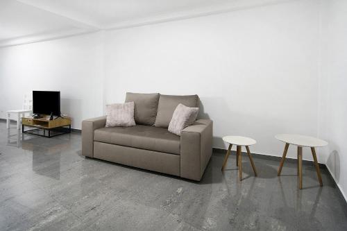 a living room with a couch and two tables at Windmill Açores Suite in Furnas