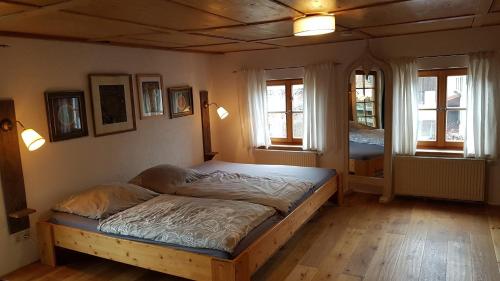 a bedroom with a large bed in a room with windows at Den Bergen Ganz Nah in Pfronten