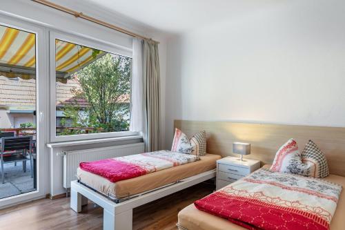 two beds in a room with a window at Ferienwohnung Am Straussee in Strausberg