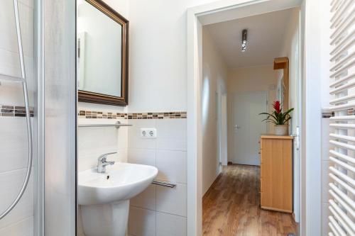 a bathroom with a sink and a mirror at Ferienwohnung Am Straussee in Strausberg