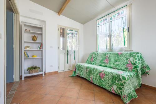 a living room with a green chair and a window at Medusa Apartment in Taormina