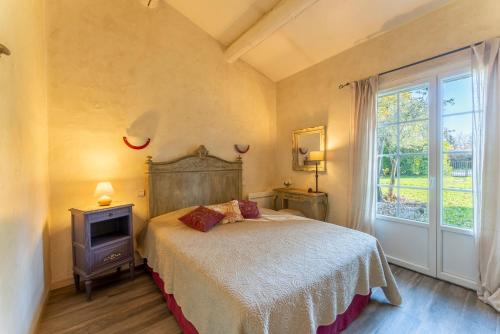 a bedroom with a bed and a window at La Rivière in Velleron