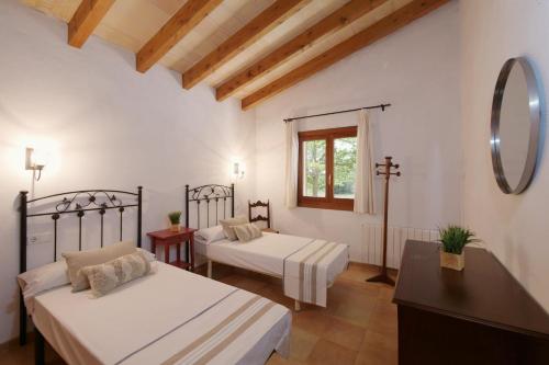 a bedroom with two beds and a mirror at Finca Port Vert in Son Servera