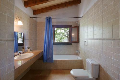 a bathroom with a tub and a toilet and a sink at Finca Port Vert in Son Servera
