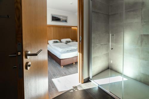 a bedroom with a bed and a glass shower at Hôtel La Métairie in Trois-Ponts