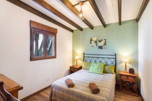 a bedroom with a bed with green walls and wooden floors at La Finca de Teror in Teror
