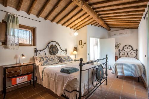 a bedroom with a bed and a wooden ceiling at La Farneta in Monteriggioni