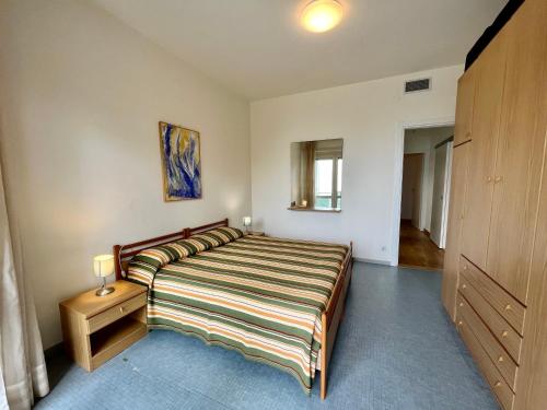 a bedroom with a large bed and a wooden cabinet at Bruseschi Appartament in Grado