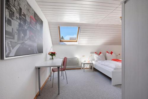 a bedroom with a bed and a desk and a table at Ferienwohnung Lange in Waldstetten