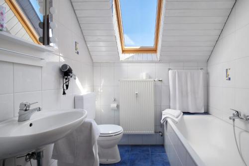 a white bathroom with a sink and a toilet at Ferienwohnung Lange in Waldstetten
