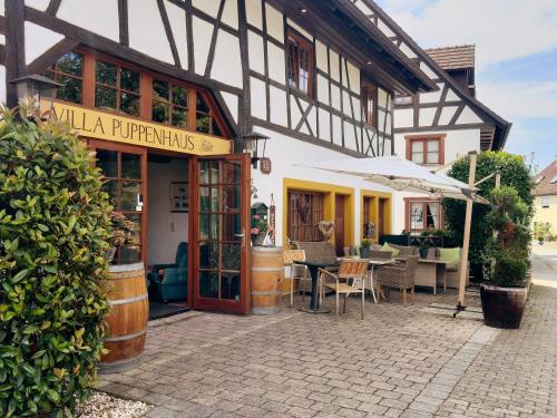 a building with a table and chairs in front of it at Villa Puppenhaus in Immenstaad am Bodensee