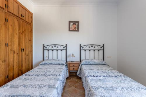 two beds sitting next to each other in a bedroom at Casa rural Villena in Frigiliana