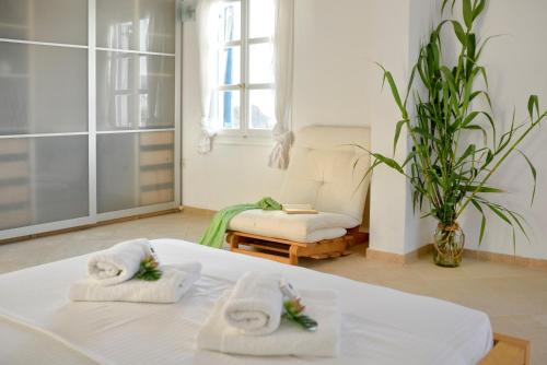 a room with two towels on a bed with a chair at Villa Crysta Mykonos in Mikonos