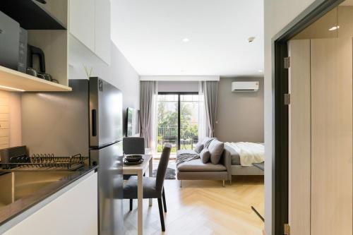 a kitchen and living room with a table and a couch at Title Legendary Studio with Balcony by TVC C407 in Bang Tao Beach