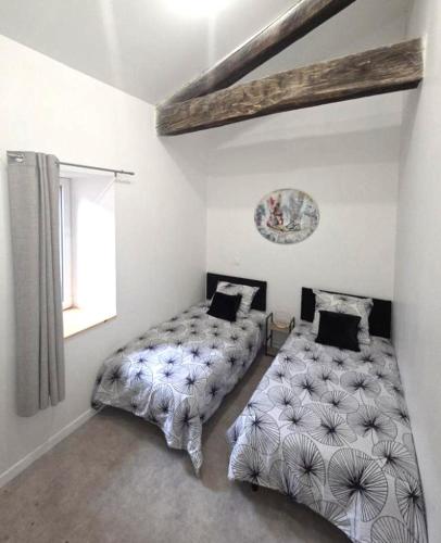 a bedroom with two beds and a window at La Traboule - Terrasse - 6 pers in Saint-Germain-Lembron