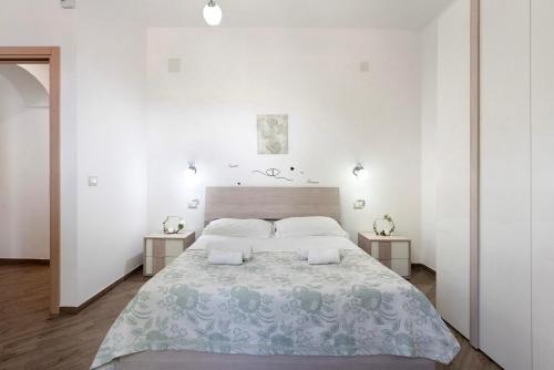a white bedroom with a large bed and two tables at Bella veduta Luna in Agerola
