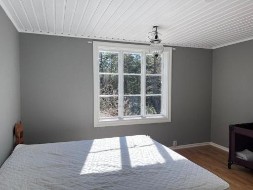 a bedroom with a white bed and a window at Enskilda stugan in Kärsta