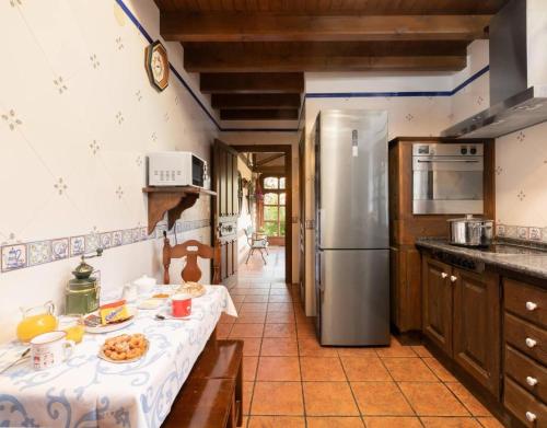 a kitchen with a table with food and a refrigerator at Casa Grau in Llanes