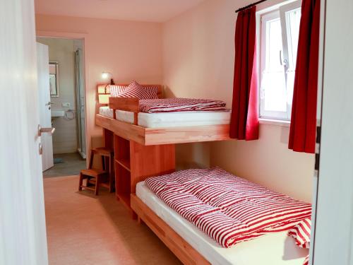 a bedroom with two bunk beds and a window at Biobauer Heubach in Iphofen