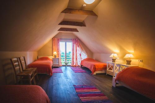 a attic room with two beds and a window at Karu Holiday Home in Laiusevälja