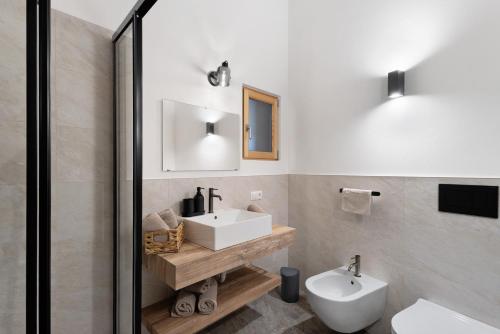 a bathroom with a white sink and a toilet at Herzleierhof Rodeneck in Rodengo