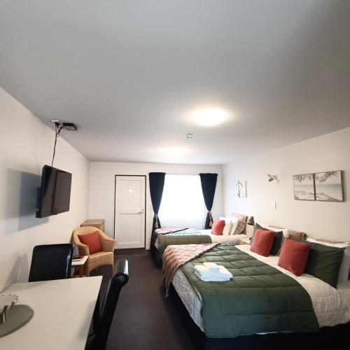 a hotel room with two beds and a desk at #4 Glenorchy Alpine Suite in Glenorchy