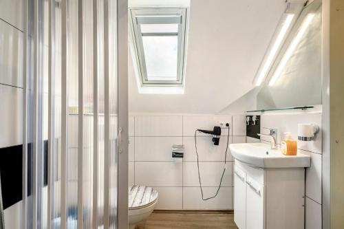 a bathroom with a toilet and a sink and a window at Picco 1 in Beuren