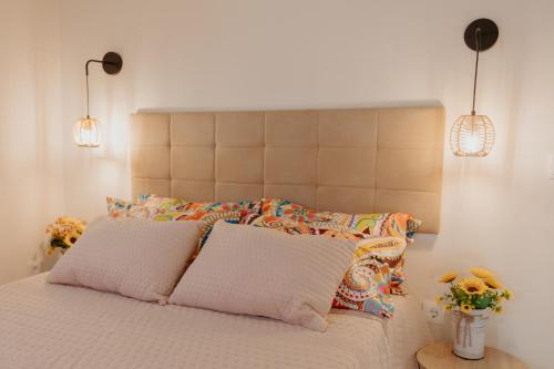a bed with two pillows and two lights above it at Cosy Tiny House Centro Vila Real in Vila Real