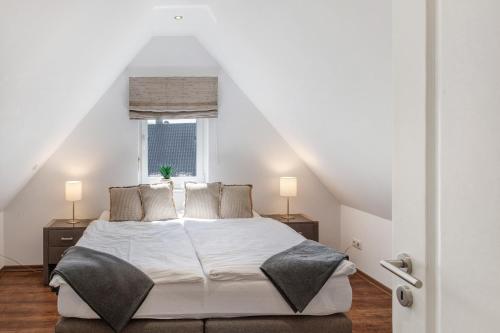 a bedroom with a white bed and a window at Villa Seebrise in Göhren-Lebbin