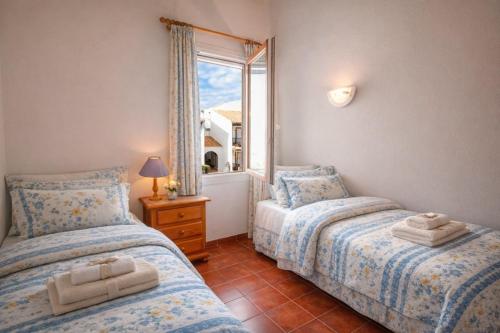 two twin beds in a room with a window at Apartamento Natalia in Menorca