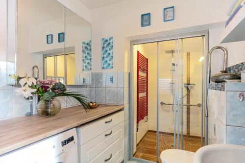 a bathroom with a shower and a vase of flowers at Kleines Haus in Bernau bei Berlin