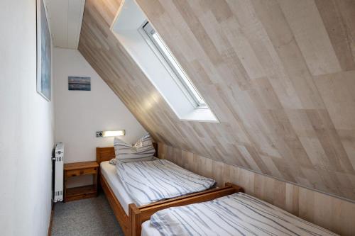 two beds in a small room with a window at Bauernhof Angelika Schulze Pellworm in Pellworm