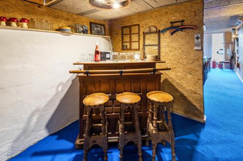 a bar with wooden stools in a room at Vogelsberger Bett Köddingen in Köddingen