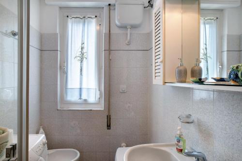 a bathroom with a sink and a toilet and a mirror at La Ca' Di Marì in Costarainera