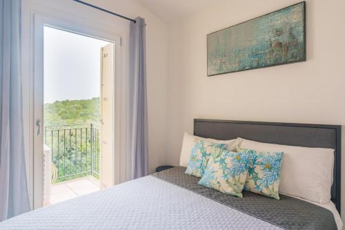 a bedroom with a bed with a view of a balcony at Appartamento Sea View in Baja Sardinia